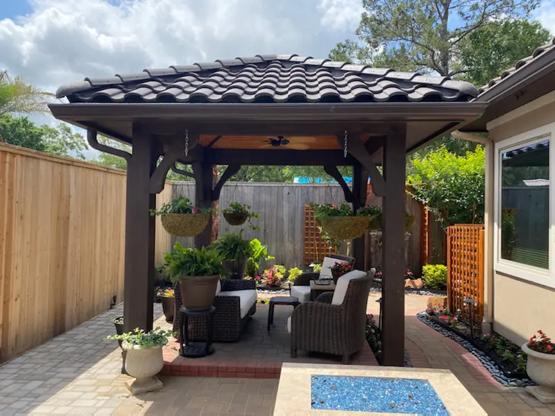 A patio with furniture and a gazebo in the middle of it.